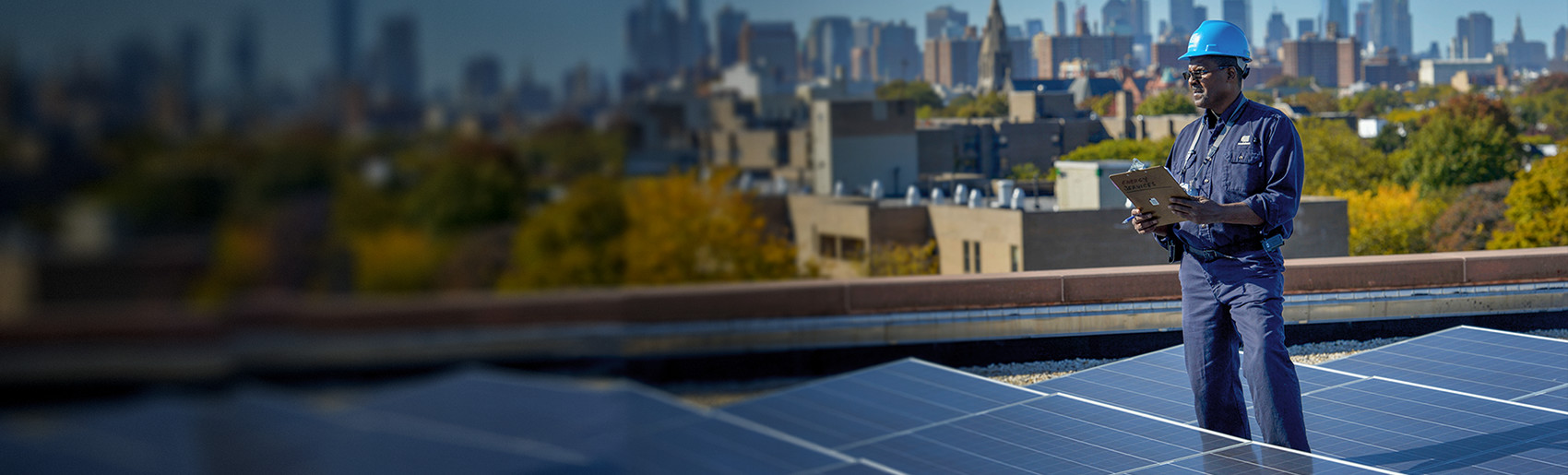 A Con Edison employee standing amid a rooftop solar installation.