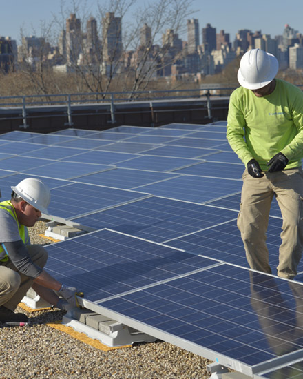 Solar panels are being installed on a rooftop in New York City