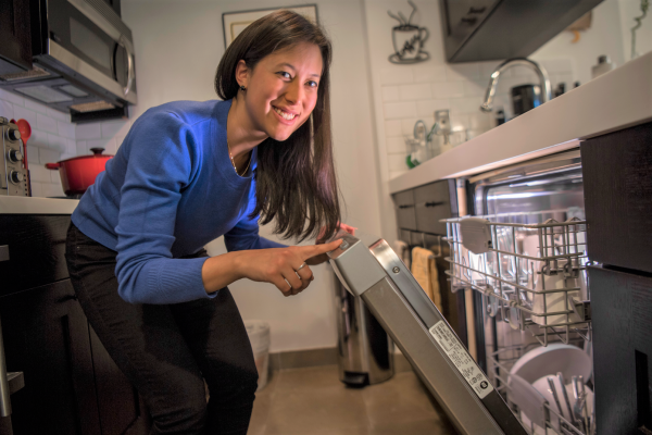 A woman opens an energy-efficient dish washer.