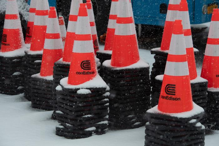 Orange safety cones covered in a light dusting of snow.