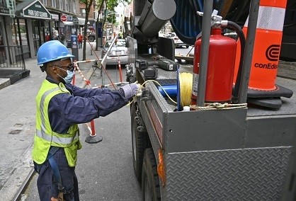 A utility worker pulls cable from the back of a truck.