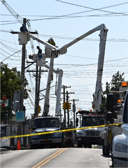 Several workers in bucket trucks repairing overhead power lines.