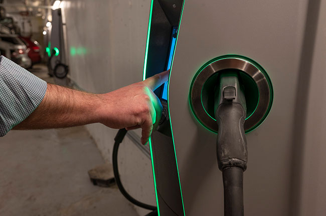 A person operating an electric charging station.