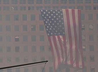 An American flag hanging outside an office building window.
