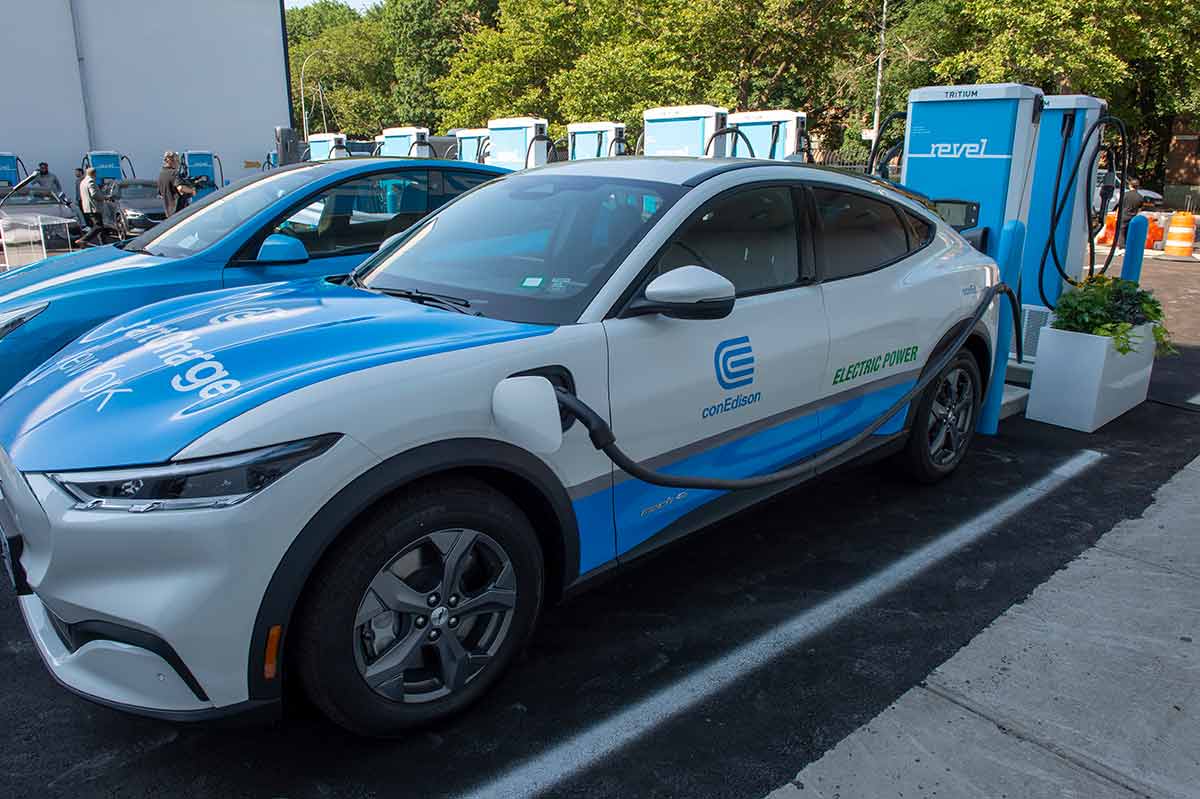 A parked Con Edison electric car plugged into a charging station.