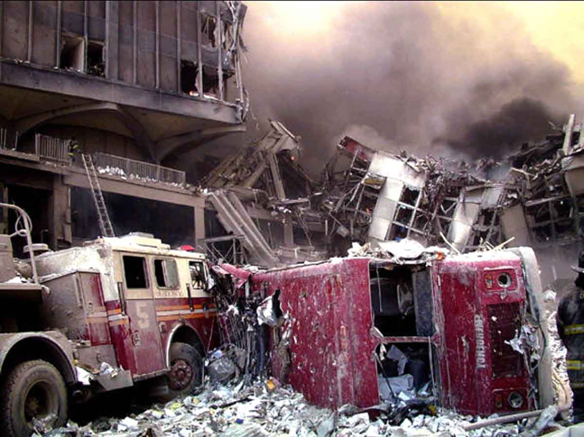 Two firetrucks toppled over next to rubble from collapsed building at World Trade Center following nine eleven.