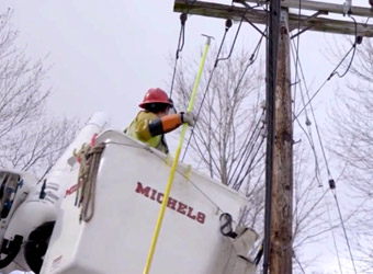 Michael's Power utility worker fixing power lines on telephone pole.