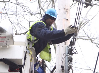 Con Edison utility worker fixing wires on a telephone pole.