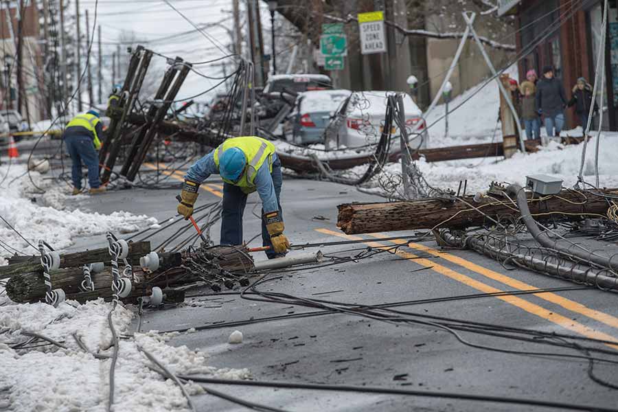 A worker repairing overhead power lines damaged during the Riley-Quinn storm events.
