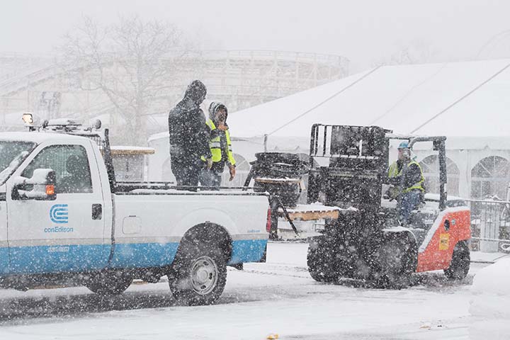 While snow is falling, Con Edison workers are unloading supplies to assist with the Riley-Quinn restoration efforts.