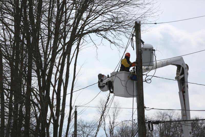 A Con Edison worker is working to restore power to overhead lines. 