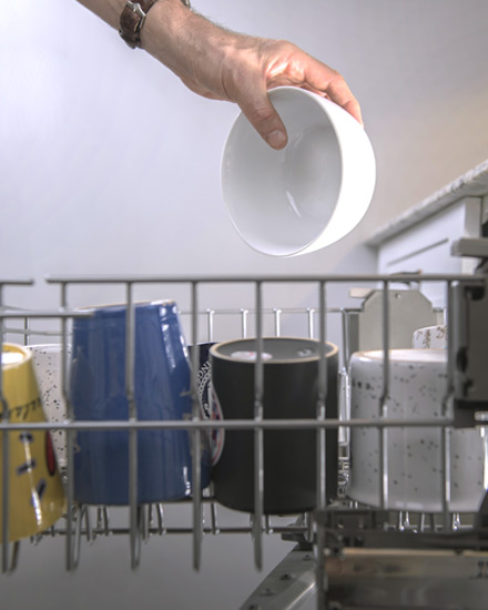 Dishes being loaded into a dishwasher.