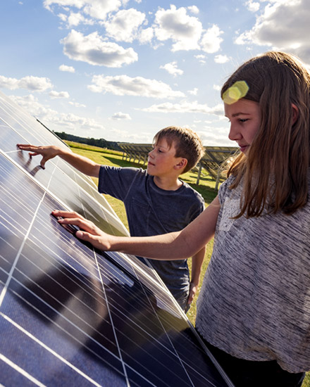 Two children examine a solar panel.