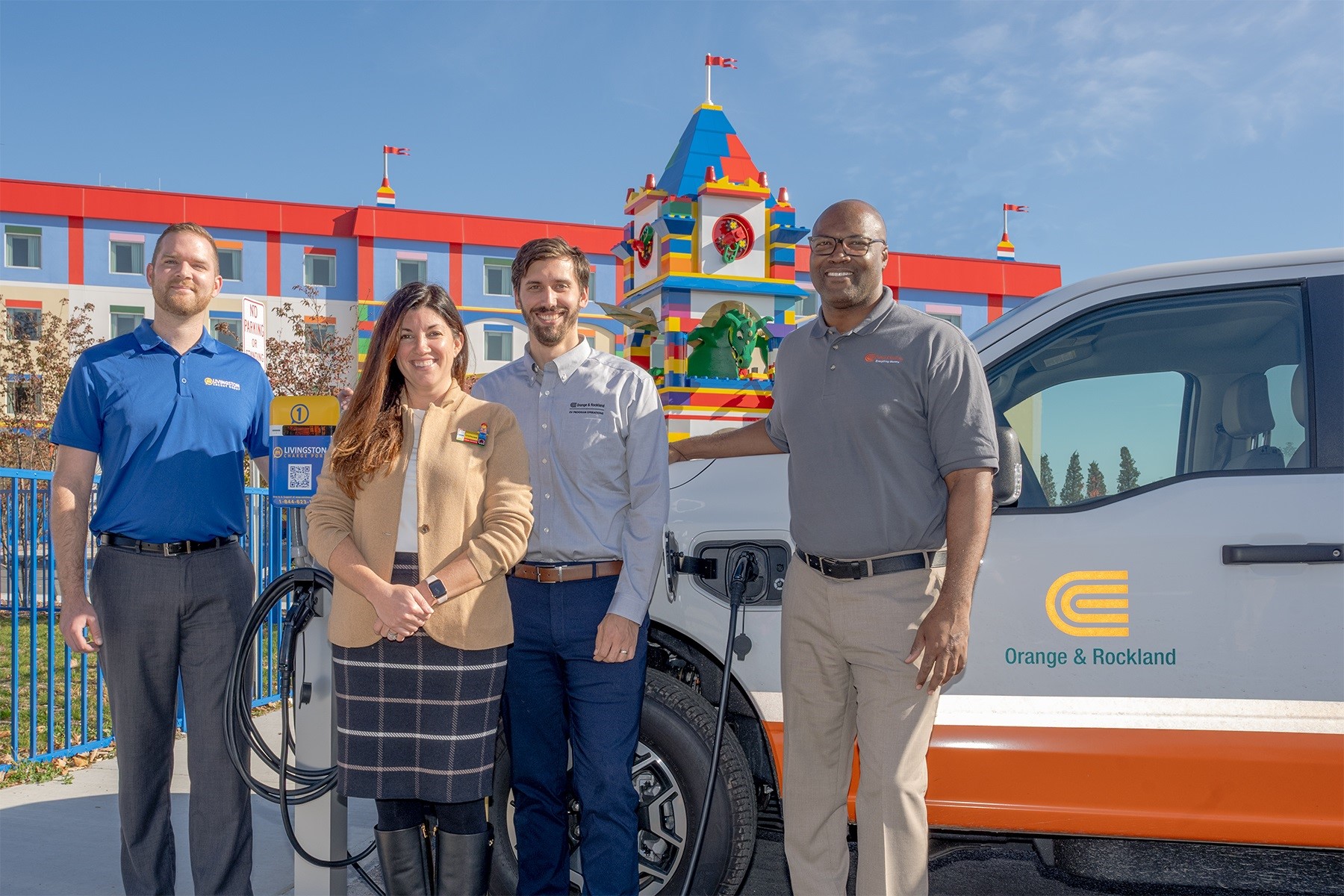 Tom Mittler, Communications Manager for Livingston Energy Group; Stephanie Johnson, LEGOLAND New York Divisional Director; Andrew Farrell, Section Manager of Orange & Rockland’s Electric Vehicle Programs and Orville Cocking, Vice President – Operations at Orange & Rockland trying out the new charger on one of O&R’s electric vehicles.